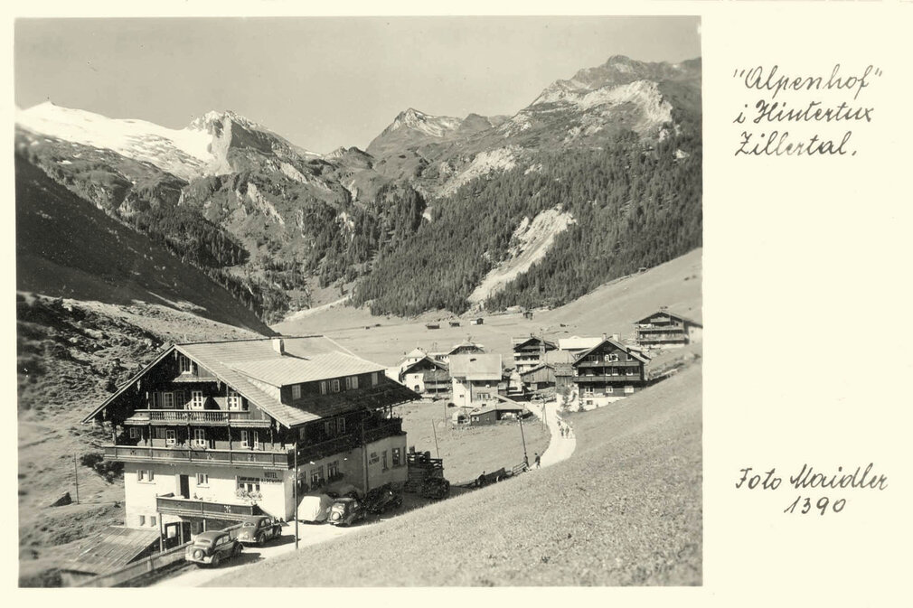 Ein historisches Foto des Alpenhofs, mit traditionellen Holzhäusern und einer ruhigen Straße im Zillertal.