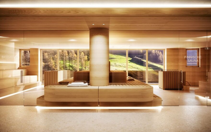 Ein modernes Saunainneres mit Holzverkleidung, großen Fenstern und Blick auf die Alpenlandschaft im Hintergrund.