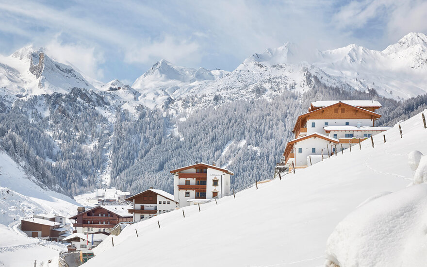Ein ruhiges Bergdorf inmitten von schneebedeckten Landschaften, wo traditionelle Architektur harmonisch mit der Natur verschmilzt.