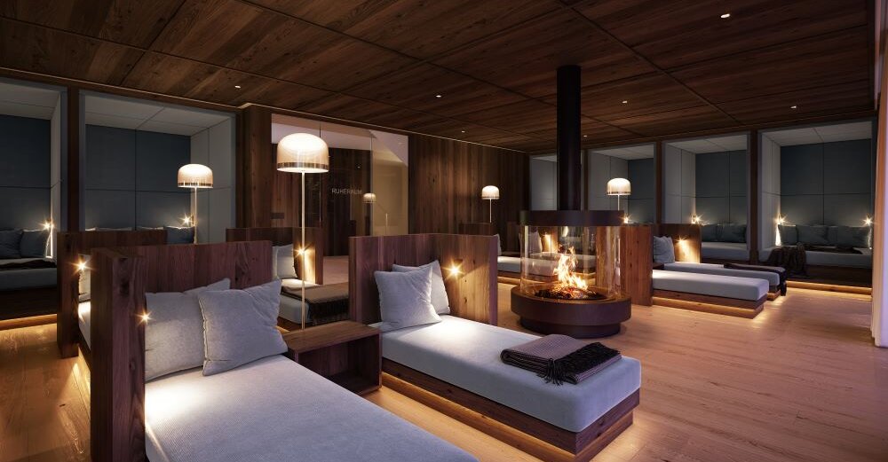 Ein stilvolles, modernes Ruheraum-Interieur mit Holzverkleidung und gemütlichen Liegen, die um einen zentralen Kamin angeordnet sind.